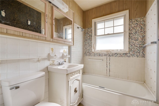 full bathroom with vanity, tile walls, toilet, and washtub / shower combination