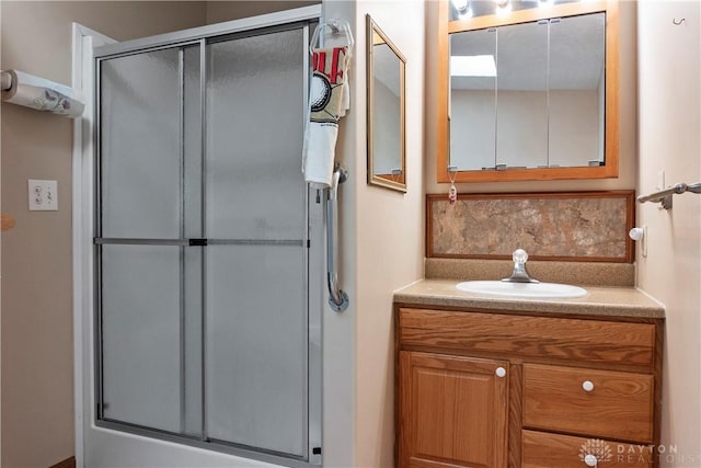 bathroom with vanity, decorative backsplash, and a shower with shower door