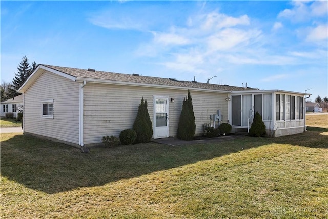 rear view of property with a yard and a sunroom