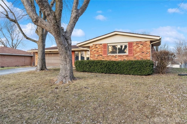 ranch-style home featuring a garage and a front lawn