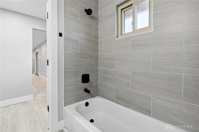 bathroom featuring tiled shower / bath combo and hardwood / wood-style flooring