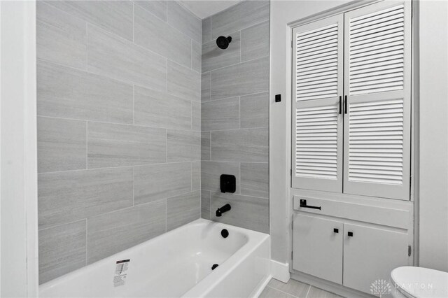 bathroom featuring tiled shower / bath and toilet