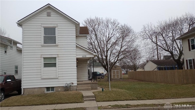 front facade featuring a storage unit and a front yard