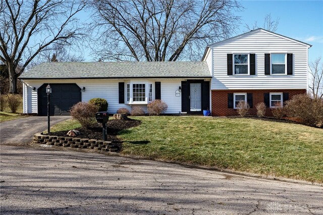 split level home featuring a garage and a front lawn