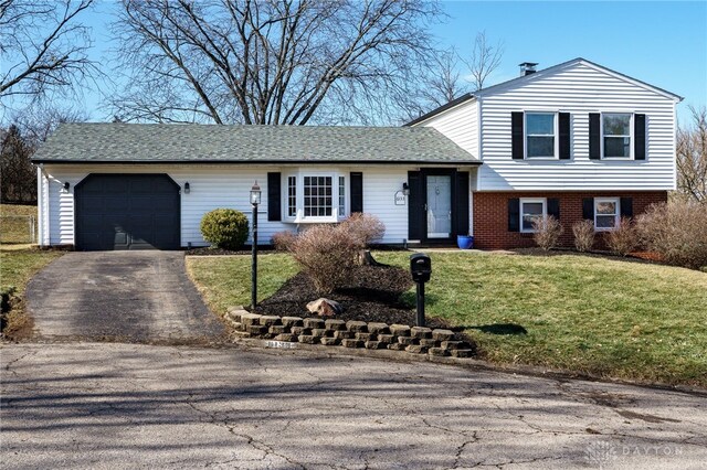 split level home featuring a garage and a front yard