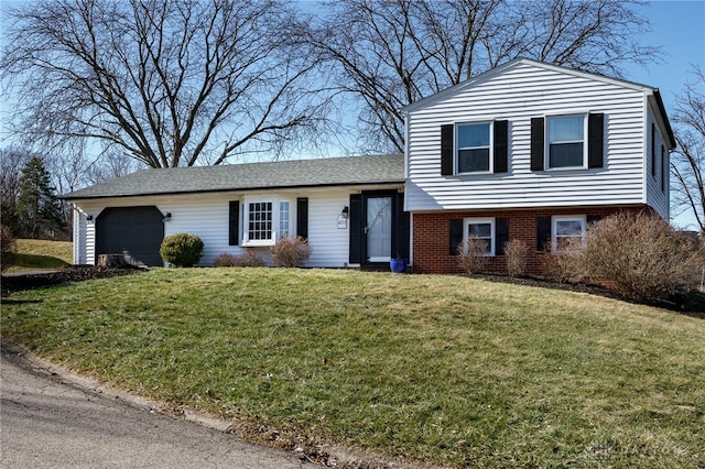 tri-level home featuring a garage and a front lawn