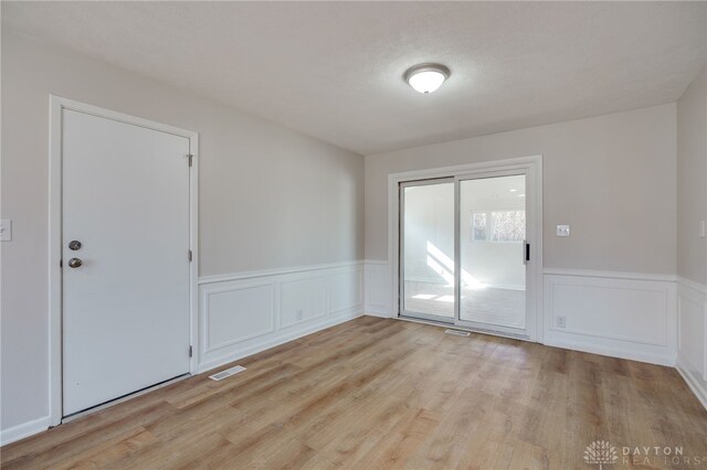 spare room featuring a textured ceiling and light wood-type flooring