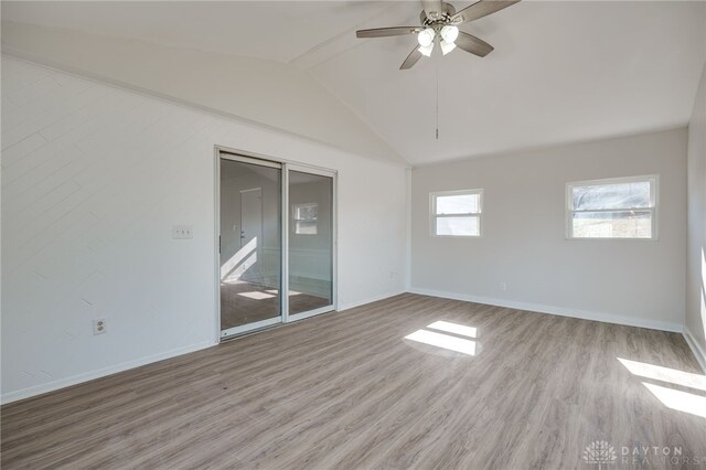 empty room featuring lofted ceiling with beams, ceiling fan, and light hardwood / wood-style floors