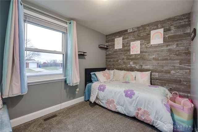 bedroom featuring carpet floors and wood walls