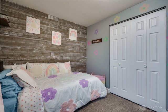 bedroom with wooden walls, carpet floors, and a closet