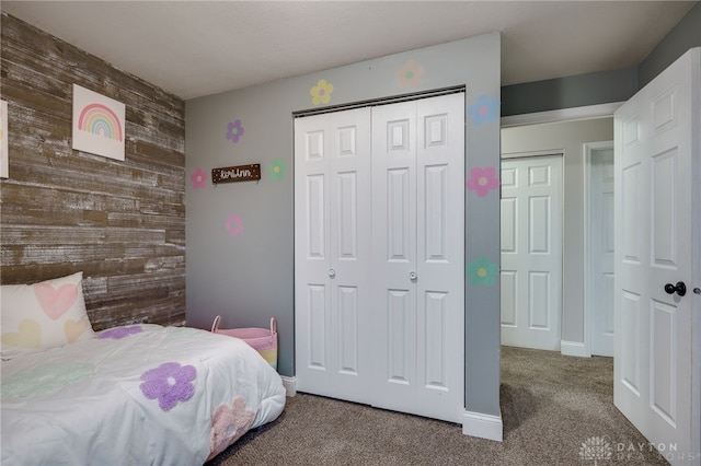 bedroom with a closet, carpet flooring, and wood walls