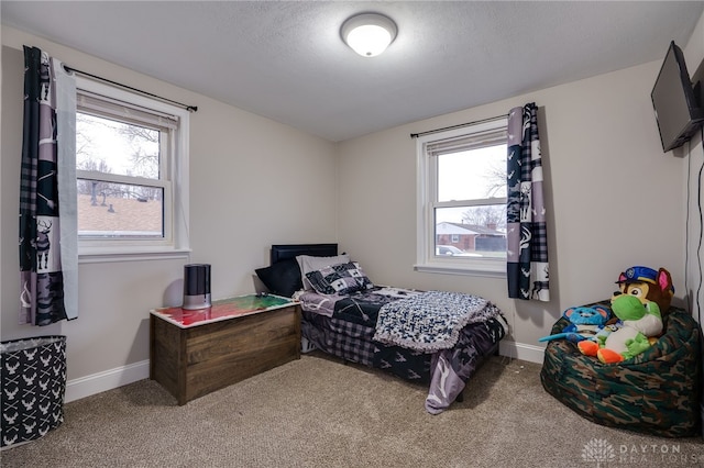 carpeted bedroom with multiple windows and a textured ceiling