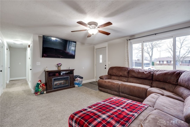 living room with a textured ceiling, ceiling fan, and carpet flooring