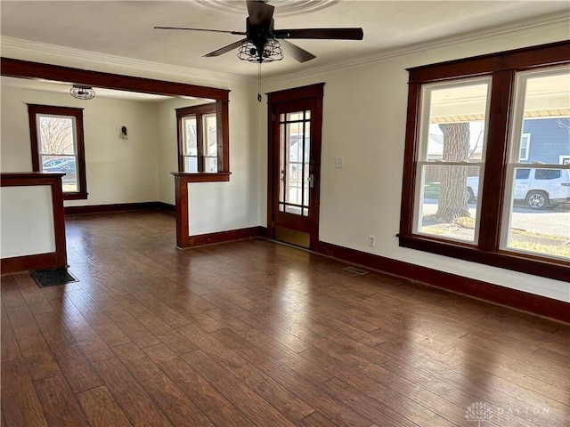 empty room with dark hardwood / wood-style flooring, crown molding, and ceiling fan