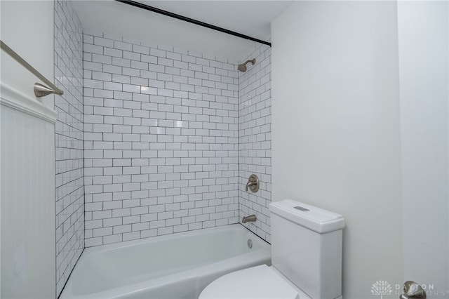 bathroom with tiled shower / bath and toilet