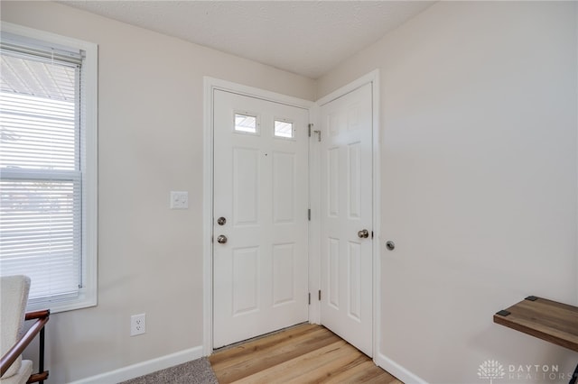 foyer featuring a textured ceiling and light wood-type flooring