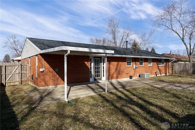 back of house featuring central AC, a patio, and a lawn