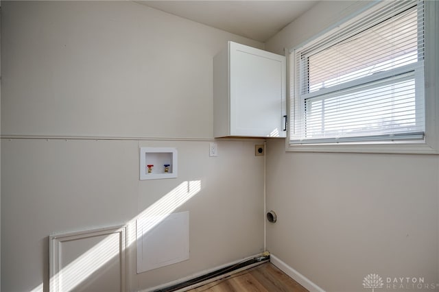 laundry area featuring cabinets, light hardwood / wood-style floors, hookup for a washing machine, and electric dryer hookup