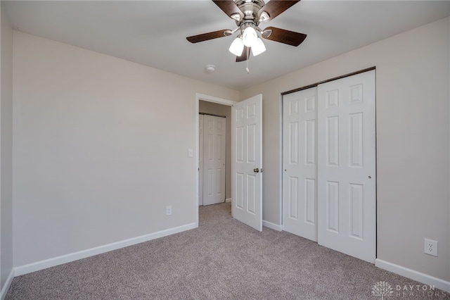 unfurnished bedroom featuring ceiling fan, a closet, and light carpet