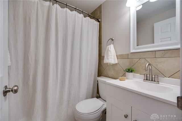 bathroom with vanity, tile walls, and toilet