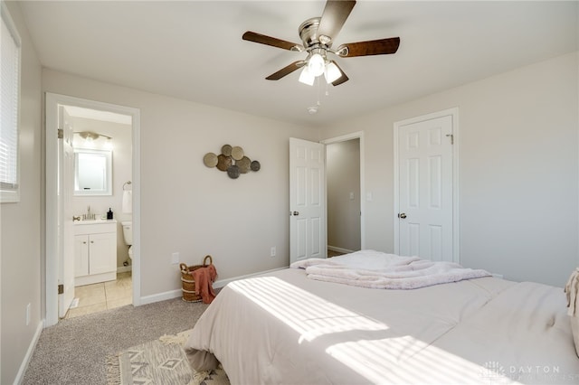 carpeted bedroom with ceiling fan and ensuite bath