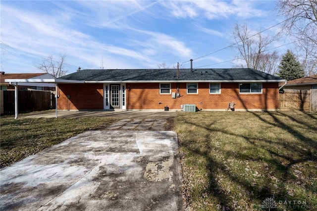 rear view of property with a yard and cooling unit