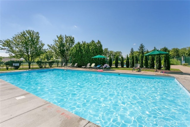 pool with a patio area and fence