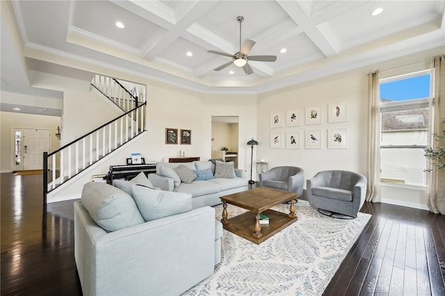 living room featuring coffered ceiling, stairs, ornamental molding, beamed ceiling, and dark wood finished floors