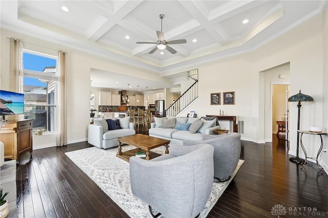 living area featuring stairs, beamed ceiling, dark wood-style flooring, and coffered ceiling