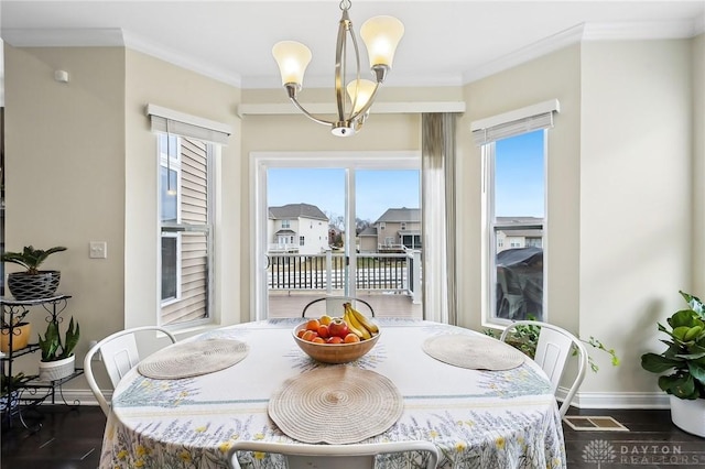 dining area featuring an inviting chandelier, baseboards, ornamental molding, and wood finished floors