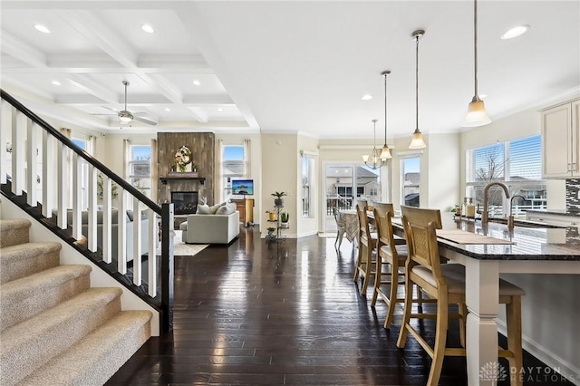 interior space with coffered ceiling, dark wood-type flooring, beamed ceiling, stairs, and recessed lighting