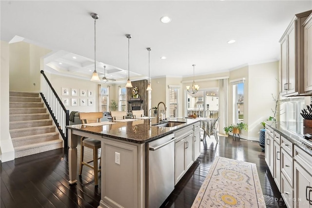 kitchen featuring dark wood-type flooring, a sink, a kitchen breakfast bar, stainless steel dishwasher, and a center island with sink