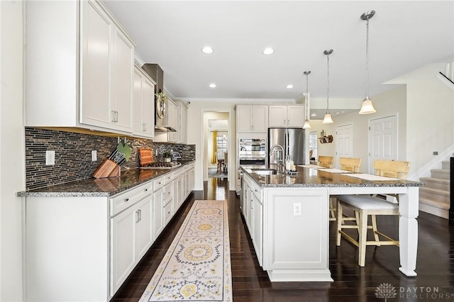 kitchen with stainless steel fridge, a breakfast bar area, dark wood-type flooring, gas cooktop, and backsplash