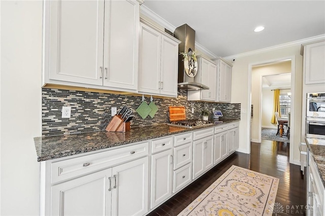 kitchen with stainless steel appliances, white cabinetry, dark wood-style floors, tasteful backsplash, and crown molding