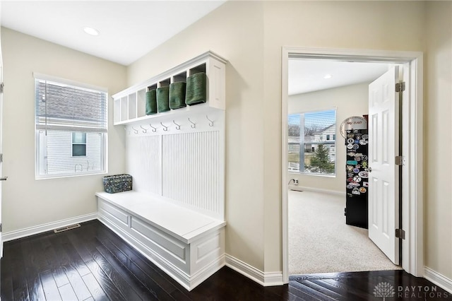 mudroom with dark wood-type flooring, visible vents, and baseboards