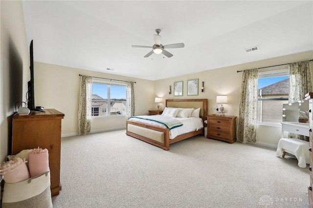 carpeted bedroom with lofted ceiling, a ceiling fan, visible vents, and baseboards