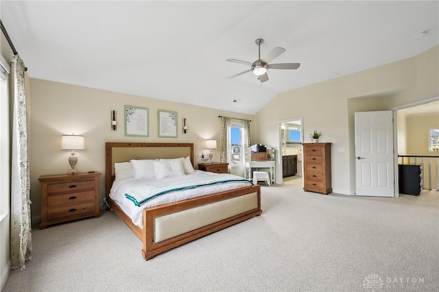 carpeted bedroom featuring vaulted ceiling, ensuite bathroom, and ceiling fan