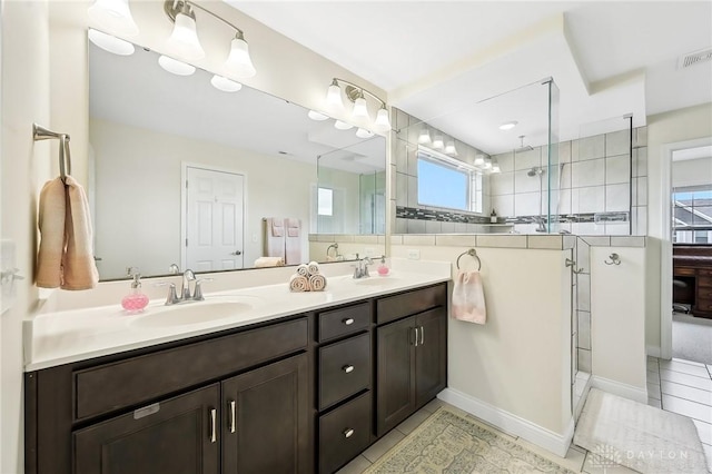 full bath featuring double vanity, a stall shower, visible vents, tile patterned flooring, and a sink