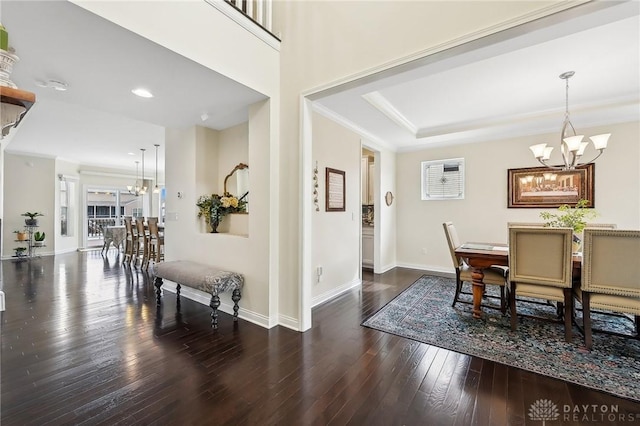 dining room featuring an inviting chandelier, baseboards, hardwood / wood-style floors, and ornamental molding