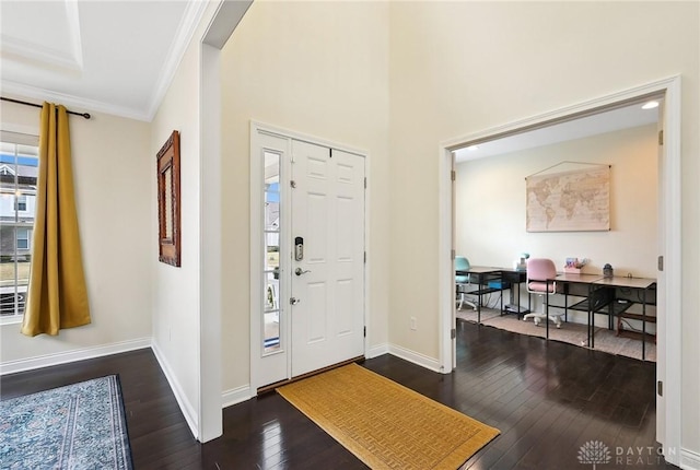 foyer entrance featuring baseboards, dark wood-type flooring, and crown molding