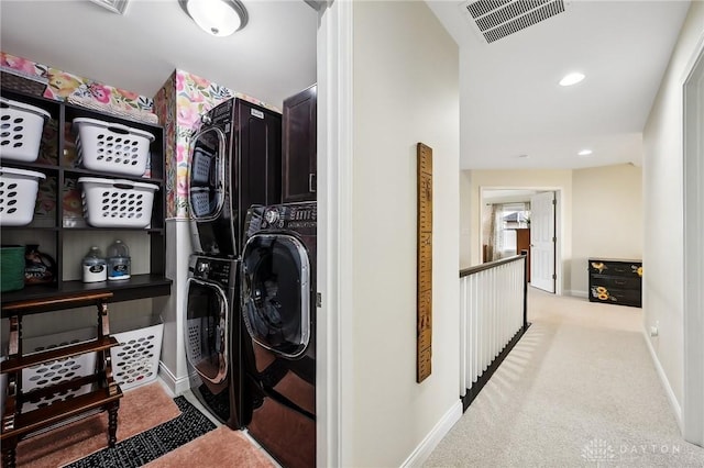 laundry room with carpet floors, visible vents, stacked washing maching and dryer, laundry area, and baseboards