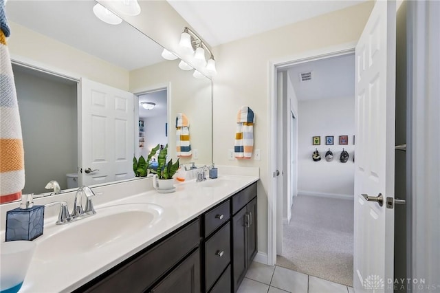 full bathroom with double vanity, visible vents, a sink, and tile patterned floors