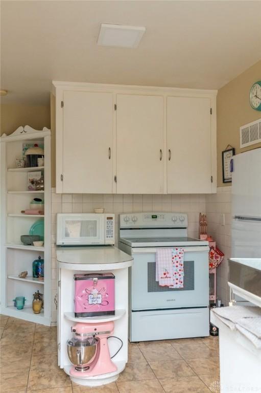 kitchen featuring white cabinetry, white appliances, backsplash, and light tile patterned floors