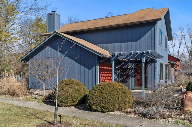 view of front facade featuring an attached garage and a chimney