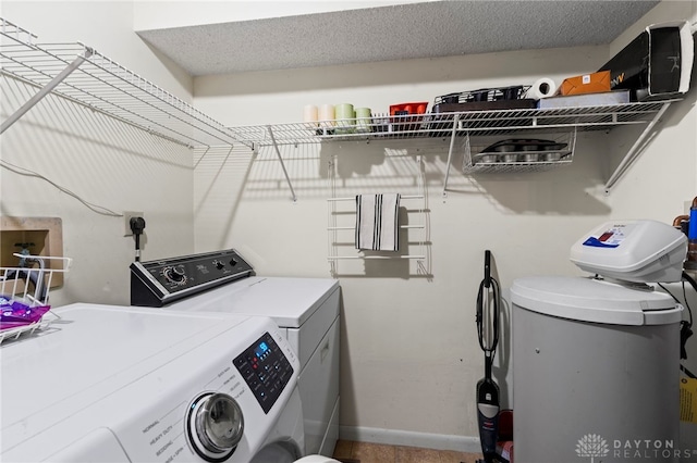 laundry area featuring baseboards, a textured ceiling, independent washer and dryer, and laundry area