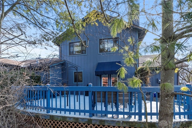 back of property featuring a chimney and a wooden deck