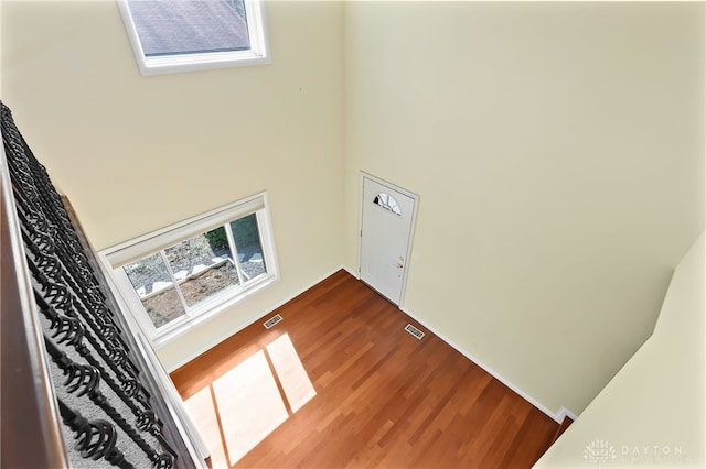 interior space with visible vents, wood finished floors, and a towering ceiling