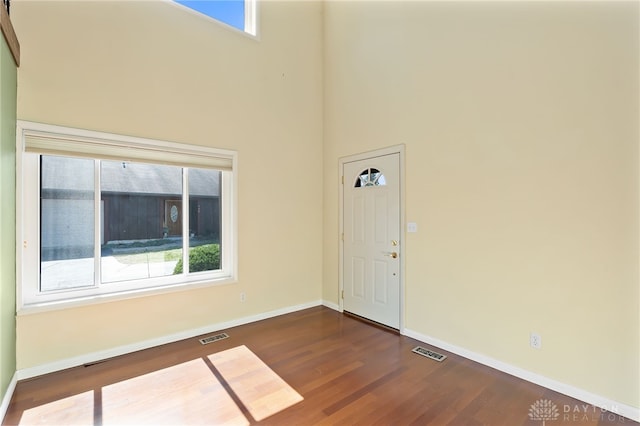 foyer featuring dark wood finished floors, plenty of natural light, and visible vents