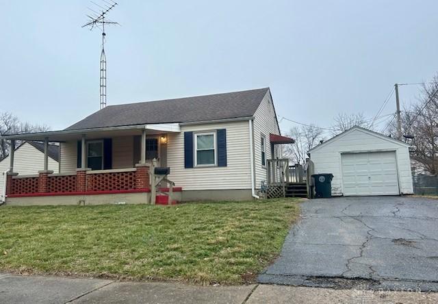 view of front of home with a garage, an outdoor structure, a front lawn, and covered porch