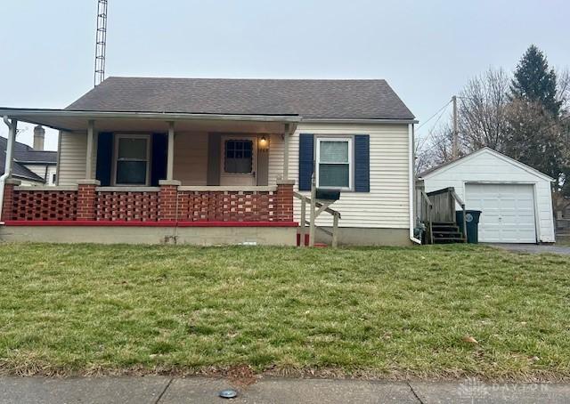 view of front of house featuring a garage, an outdoor structure, a porch, and a front yard